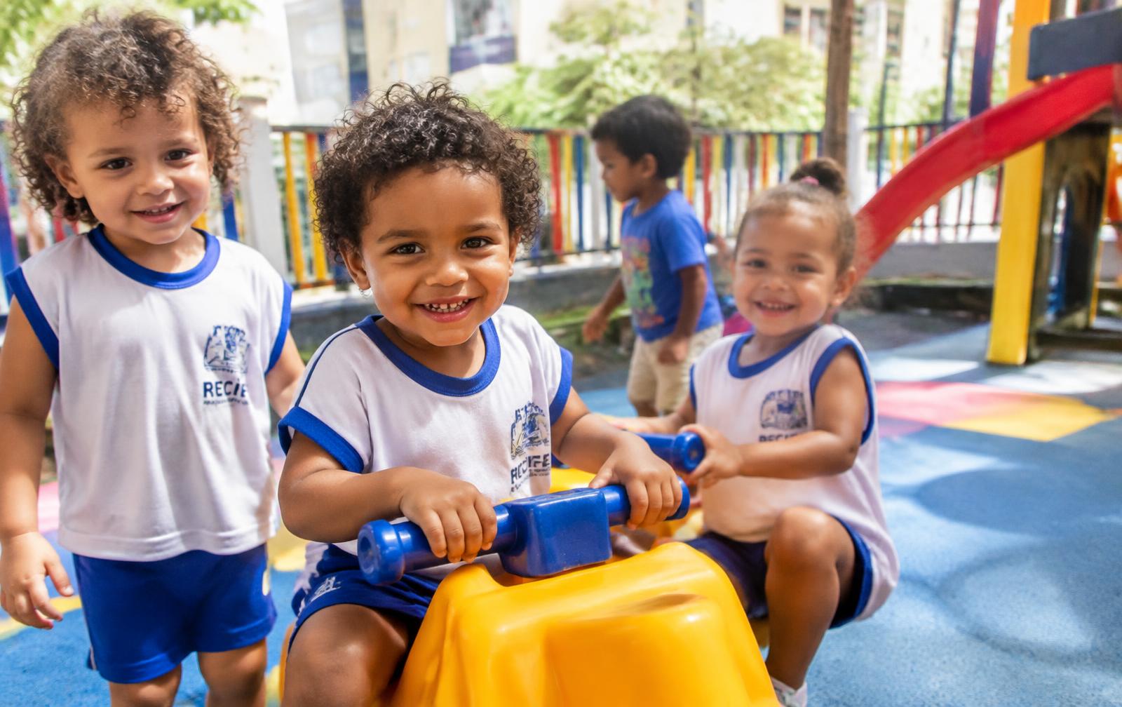 Crianças sorrindo no parquinho da creche